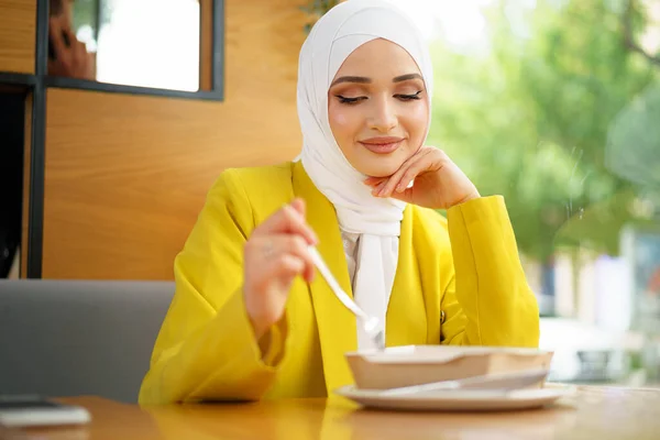 Jonge moslim vrouw in hijab lunchen in café — Stockfoto