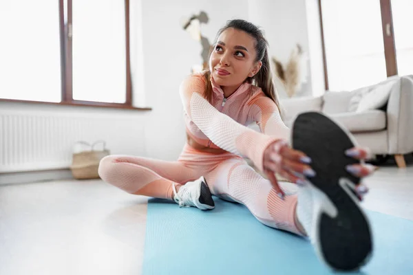 Young fit woman doing stretching exercises at home — Stock Photo, Image