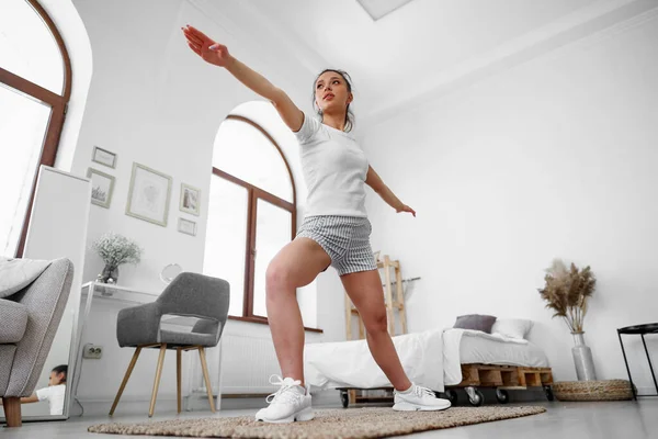 어린 건강 소녀 가집 거실에서 운동을 하고 있다 — 스톡 사진