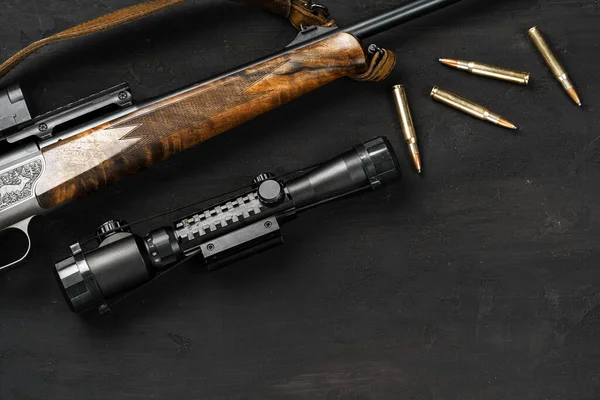 La mira óptica y la escopeta en backgorund de madera — Foto de Stock