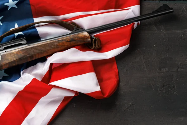 Rifle automático sobre bandera de Estados Unidos sobre fondo de madera — Foto de Stock