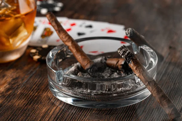 Doutník a hrací karty na stole kasina — Stock fotografie