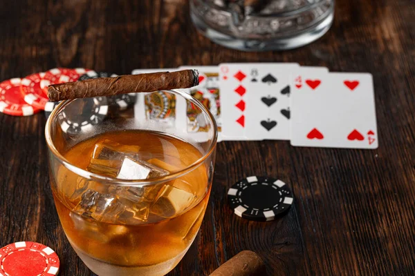 Cuban cigar, whiskey glass and chips on table Stock Image