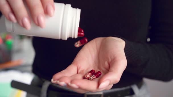 Zbliżenie kobiety wylewającej kapsułki z butelki z lekami na rękę — Wideo stockowe