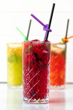 Beyaz ahşap arka planda üç farklı ferahlatıcı limonata.