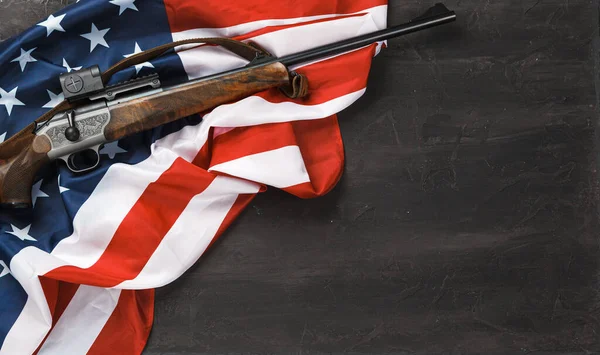 Rifle automático sobre bandera de Estados Unidos sobre fondo de madera — Foto de Stock