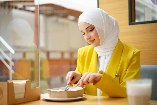 Jonge moslim vrouw in hijab lunchen in café — Stockfoto