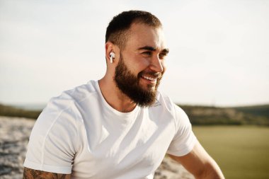 Kırsalda yürürken müzik dinleyen bir sporcunun fotoğrafını çek.