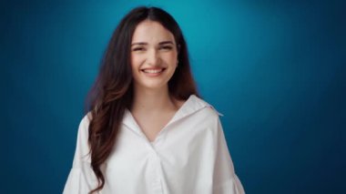Gülümseyen ve gülen neşeli genç bir kadın.