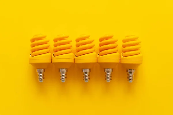 Glühbirne auf gelbem Papier Hintergrund von oben — Stockfoto