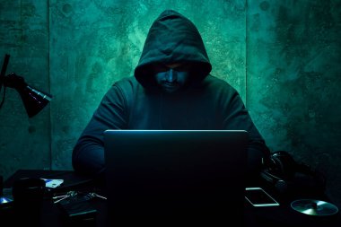 Bilgisayar programcısı karanlık odada bilgisayar kullanıyor