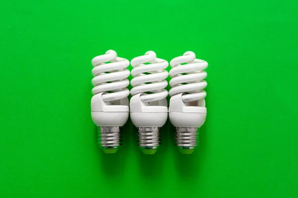 Glühbirne auf grünem Papier Hintergrund Nahaufnahme — Stockfoto