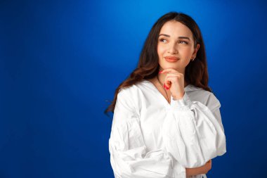 Genç ve düşünceli bir kadın bir fikir düşünüyor.