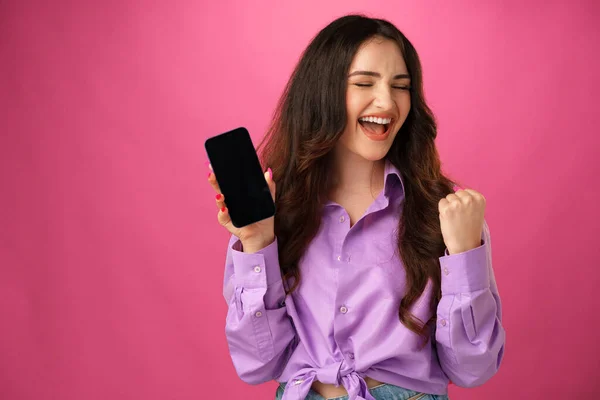 Attraente giovane donna che mostra schermo dello smartphone vuoto con spazio di copia — Foto Stock