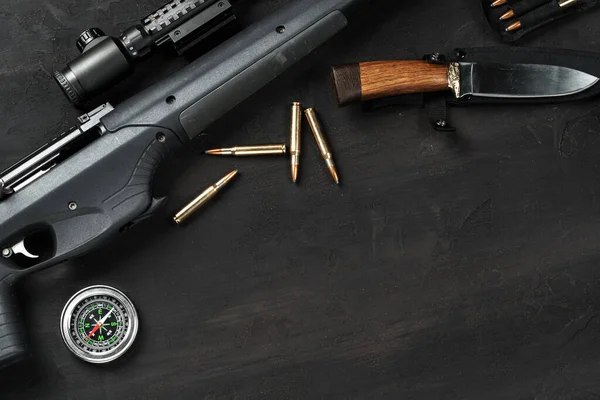 Мисливська гвинтівка та набої на темному дерев'яному фоні — стокове фото