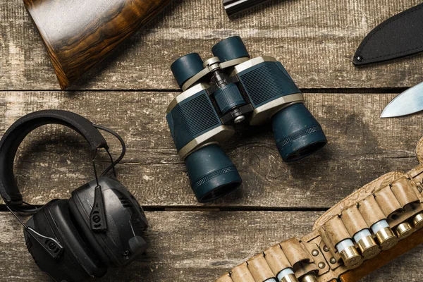 ライフル、ナイフ、双眼鏡、カートリッジなどの古い木製の背景に狩猟装置 — ストック写真