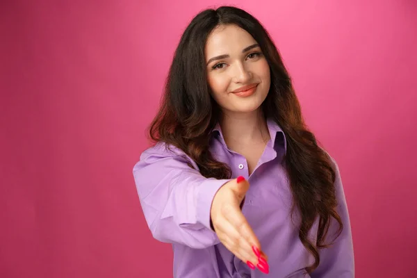 Joven morena dando la mano para el apretón de manos sobre fondo rosa —  Fotos de Stock