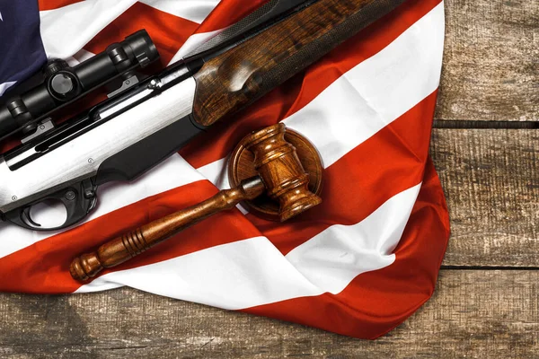 Juez de madera mazo y rifle de caza sobre bandera de EE.UU. sobre fondo de madera — Foto de Stock