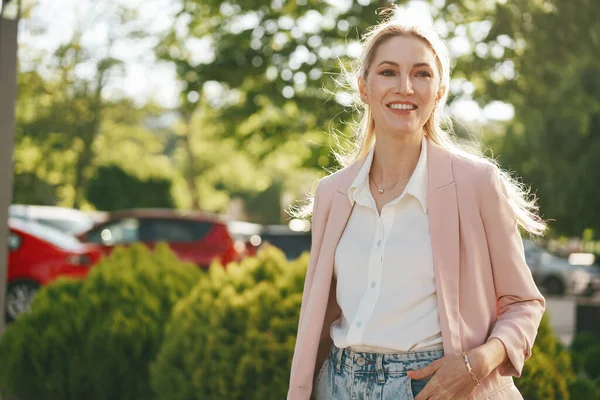 Stijlvolle jonge zakenvrouw wandelen op de stad straat op zonnige dag — Stockfoto