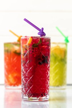 Beyaz ahşap arka planda üç farklı ferahlatıcı limonata.