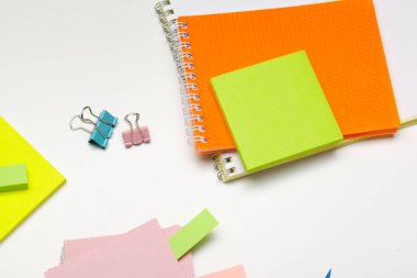 Kalemleri, renkli kalemleri, masa üzerinde ataçları olan yapışkan notlar.