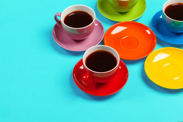 Copos de café coloridos e pires em fundo colorido vibrante — Fotografia de Stock