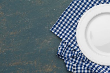 Boş tabak ve havlu ahşap masa arka planında.
