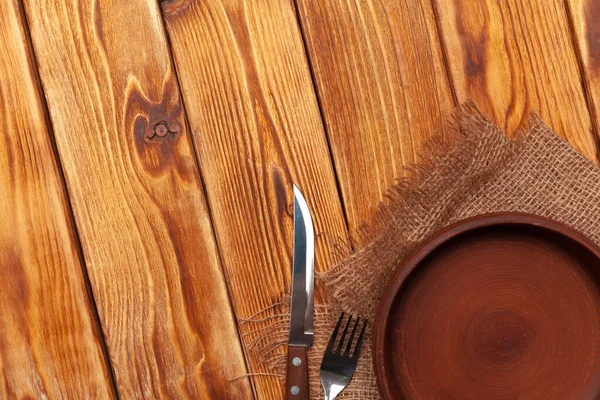 Empty plate and towel over wooden table background. — Stock Photo, Image