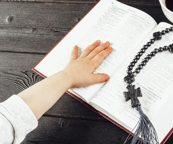 Hände eines kleinen christlichen Kindes und Bibel auf Holztisch — Stockfoto