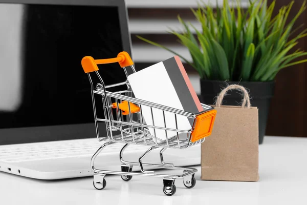 Conceito de compras online. Carrinho de compras, laptop na mesa — Fotografia de Stock