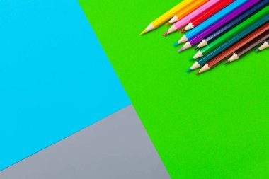 Parlak renkli kağıt arka planında renkli kalemler