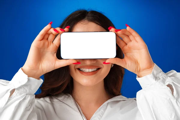 Atrakcyjna młoda kobieta pokazuje pusty ekran smartfona z przestrzenią do kopiowania — Zdjęcie stockowe
