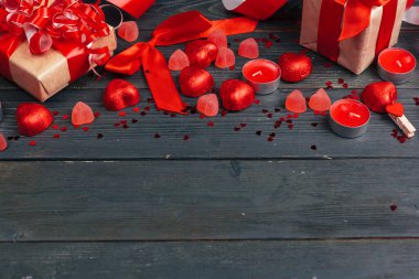 Tahta masada kırmızı kalpler olan hediye kutusu.