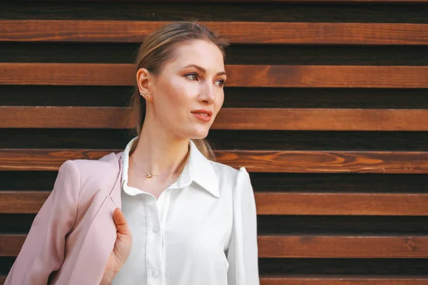Aantrekkelijke jonge stijlvolle vrouw staande tegen houten muur — Stockfoto