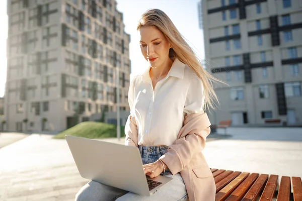 Joven empresaria exitosa que utiliza el ordenador portátil para trabajar al aire libre —  Fotos de Stock