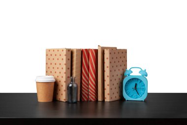 Alarm saati, beyaz arkaplan karşısında kitap yığını ve fincan