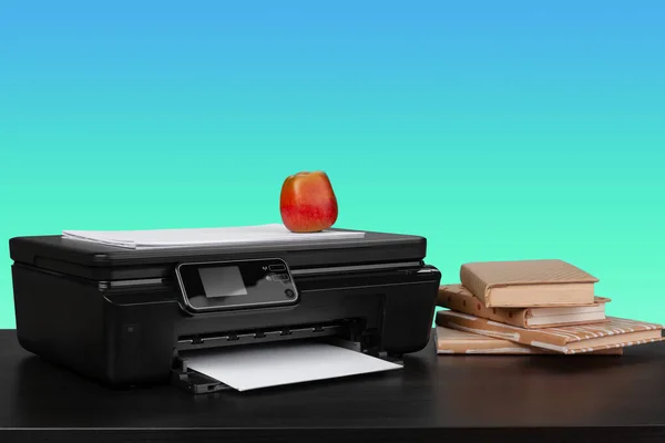 Home laser printer on desk against green background