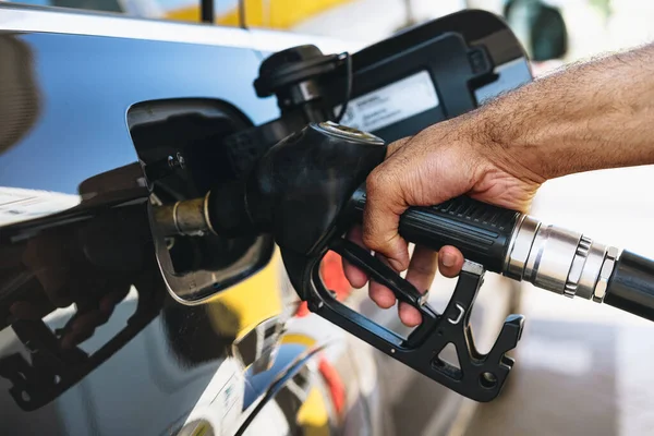 Man filling gasoline fuel in car at gas station