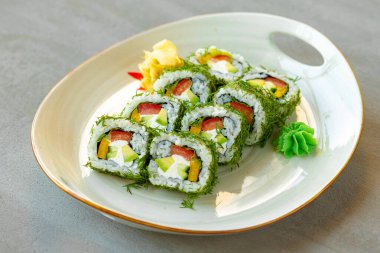 Ahşap arka planda dereotlu ve sebzeli vejetaryen suşisi rulosu.