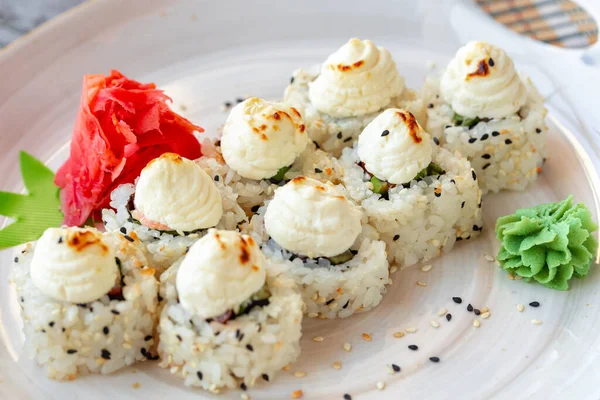 Japanese sushi with sesame seeds and cream icing on gray background — Stock Photo, Image