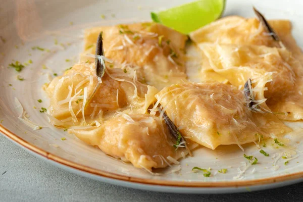 Italiensk maträtt ravioli med parmesan i en tallrik — Stockfoto