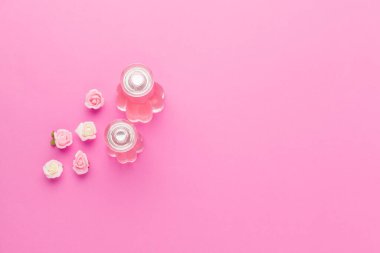 Pembe arka planda parfüm şişeleri
