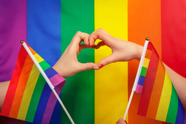 ゲイのプライドでハートサインをする手｜LGBTの虹の旗 — ストック写真