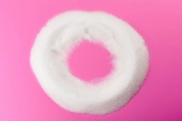 White sugar on a pink background top view — Stock Photo, Image
