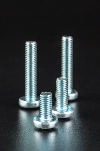 Screws on black background — Stock Photo, Image