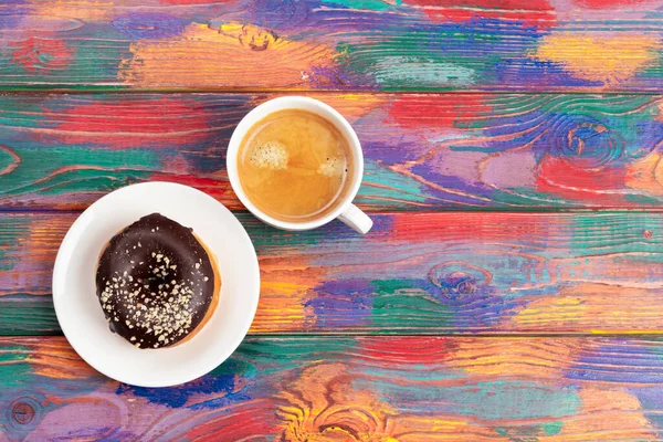 Frischer Donut mit Kaffee auf Holzoberfläche, Draufsicht — Stockfoto