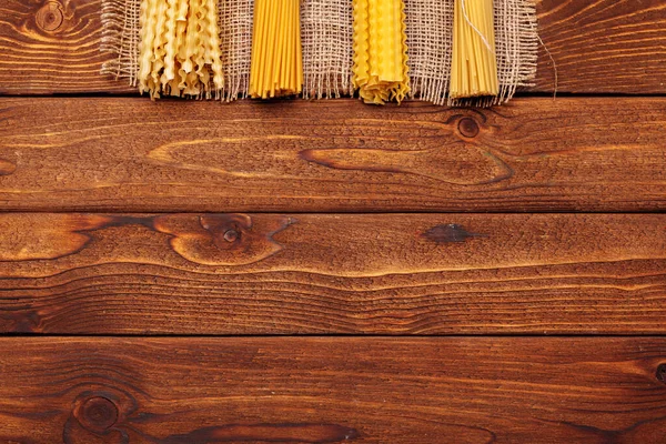 Gedroogde pasta op houten ondergrond — Stockfoto