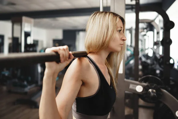 Spor kıyafetli kadın spor salonunda egzersiz yapıyor. — Stok fotoğraf