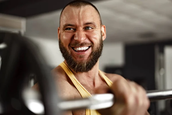 유쾌하게 미소짓는 남자 보디빌더 가 체육관에서 있다 — 스톡 사진