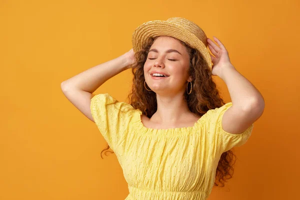 Portrait d'une jeune femme aux cheveux bouclés sur fond jaune — Photo